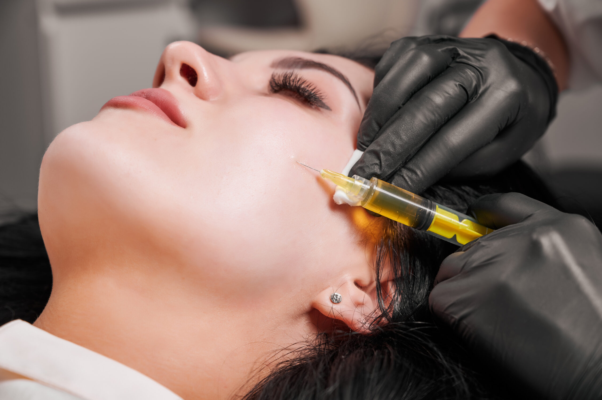 Female doctor making injection in woman chin.